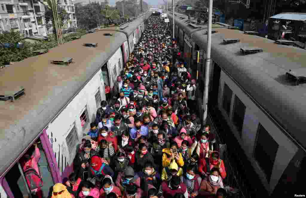 Commuters disembark from a suburban train, amidst the spread of the COVID-19, at a railway station on the outskirts of Kolkata, India, Jan. 5, 2022.