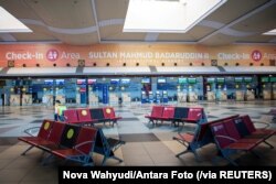 Seorang petugas di terminal keberangkatan pada hari pertama pemberlakuan larangan mudik Idul Fitri dari 6-17 Mei, di Bandara Internasional Sultan Mahmud Badaruddin II di Palembang, Sumatra Selatan, 6 Mei 2021. (Foto: Nova Wahyudi/Antara Foto via Reuters)
