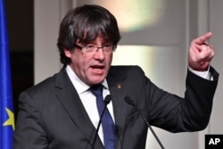 FILE - Ousted Catalan leader Carles Puigdemont addresses Catalan mayors who traveled to Brussels in support of the ousted Catalan government in Brussels, Belgium, Nov. 7, 2017.
