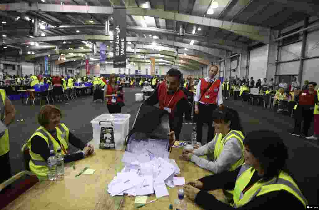 A ballot box with the first non-postal votes is emptied at a counting center in Ingliston in Edinburgh, Scotland, Sept. 18, 2014.