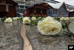 Roses sit beside a new memorial - a crack in the ground - after its opening in Berlin, Germany, Dec. 19, 2017, to honor the victims of the Christmas market terrorist attack on the Breitscheid square at the Kaiser Wilhelm Memorial Church one year ago.