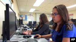 In this April 30, 2015 photo, Leticia Fonseca, 16, left, and her twin sister, Sylvia Fonseca, right, work in the computer lab at Cuyama Valley High School in New Cuyama, Calif. (AP Photo/Christine Armario)