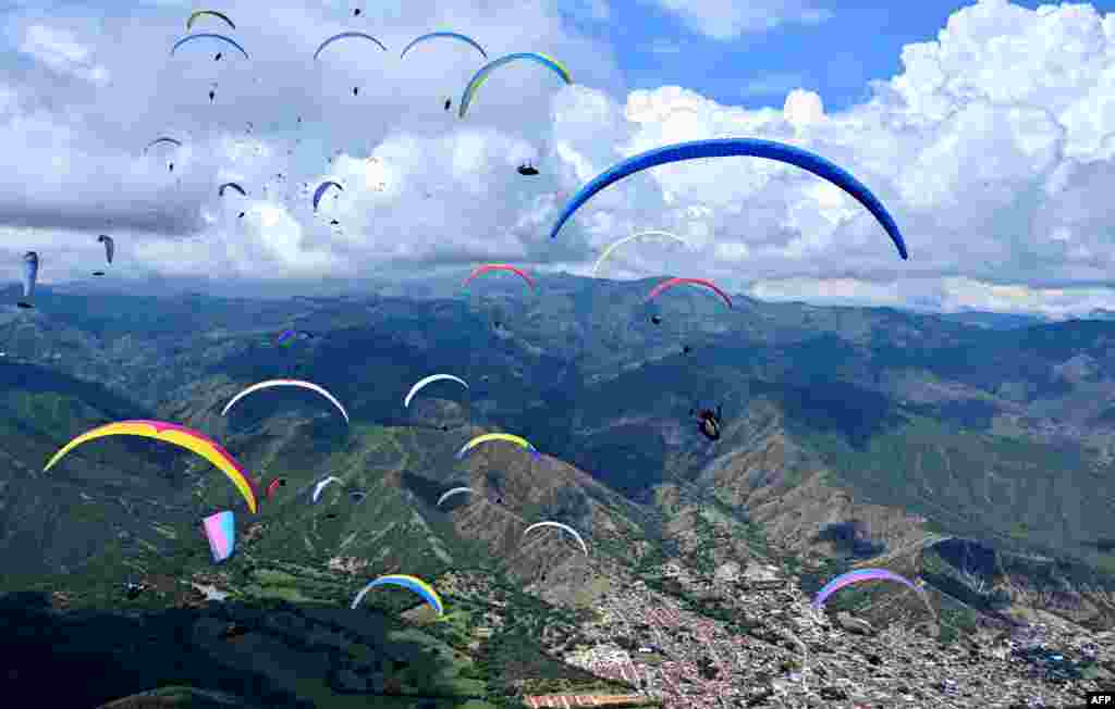 Paraglider pilots fly over the mountains in Roldanillo, Valle del Cauca Department, Colombia, during the British Winter Open, Jan. 25, 2020.