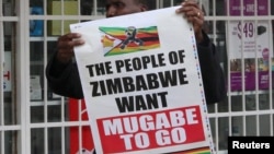 A man carries a poster calling for Zimbabwe President Robert Mugabe to step down as Zimbabweans take to the streets in Harare, Zimbabwe, Nov. 18, 2017. 