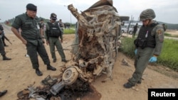 FILE - Military personnel stand next to a damaged military vehicle where soldiers were attacked by suspected Muslim militants at Muang district in the southern province of Yala, Thailand, Sept. 4, 2015. 