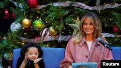 La primera dama de EE.UU. recibe un aplauso de Tearrianna Cooke-Starkey mientras lee un cuento de Navidad para niños durante su visita al Hospital de Niños de Washington, 13 de diciembre de 2018. (REUTERS / Kevin Lamarque)