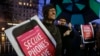 A man holds up his iPhone during a rally in support of data privacy outside an Apple store in San Francisco, Calif., Feb. 23, 2016. Protesters lashed out at a government order requiring Apple to help unlock an encrypted iPhone.