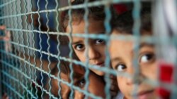 غزہ پر حالیہ اسرائیلی بمباری کے بعد گھر سے اقوام متحدہ کی نگرانی والے ایک اسکول میں پناہ لینے والے بچے کھڑکی سے جھانگ رہے ہیں (رائٹرز)