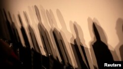 FILE - Shadows of members of a panel are seen on a wall before a meeting about the "right to be forgotten" in Madrid, Sept. 9, 2014. 