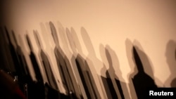 FILE - Shadows of members of a panel appear on a wall before a meeting about the "right to be forgotten" in Madrid, Sept. 9, 2014. 