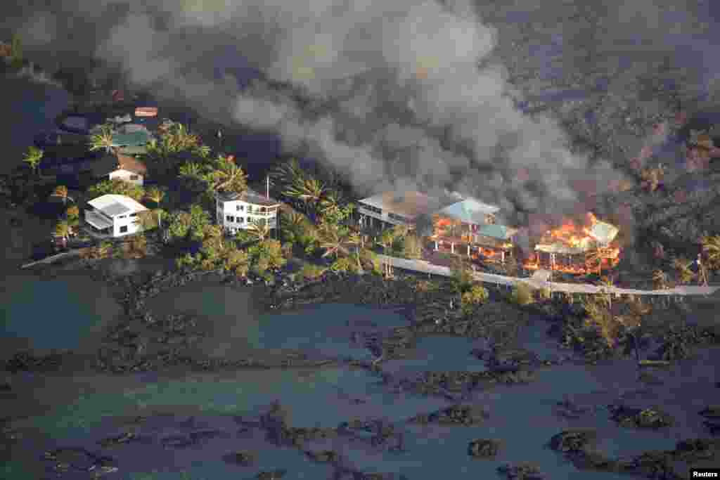 Muntahan lava menghancurkan rumah-rumah di kawasan Kapoho, kota Pahoa timur, saat letusan gunung berapi Kilauea di Hawaii, AS.