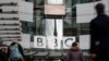 Seorang pejalan kaki melewati logo BBC di Broadcasting House, saat perusahaan mengumumkan akan memangkas sekitar 450 pekerjaan dari divisi beritanya, di London, Inggris, 29 Januari 2020. (Foto: REUTERS/Henry Nicholls)