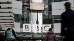 Seorang pejalan kaki melewati logo BBC di Broadcasting House, saat perusahaan mengumumkan akan memangkas sekitar 450 pekerjaan dari divisi beritanya, di London, Inggris, 29 Januari 2020. (Foto: REUTERS/Henry Nicholls)