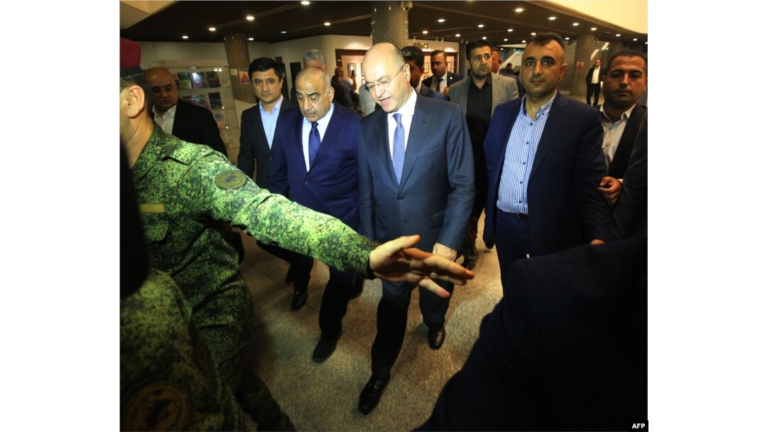 Adel Abdul Mahdi (3rd L) walks out of the Parliament with newly-elected Iraqi President Barham Saleh (C) in Baghdad on Oct. 2, 2018.