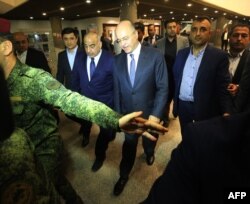 Adel Abdul Mahdi (3rd L) walks out of the Parliament with newly-elected Iraqi President Barham Saleh (C) in Baghdad on Oct. 2, 2018.