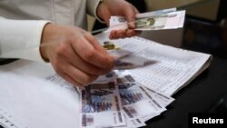 A cashier counts a pension payment in Russian roubles, in a post office at the Crimean city of Simferopol, March 25, 2014. 