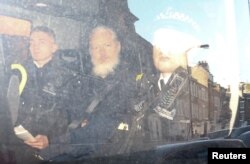 WikiLeaks founder Julian Assange, center, leaves the Westminster Magistrates Court in the police van, after he was arrested in London, Britain, April 11, 2019.