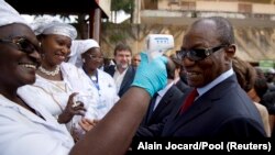 Le président guinéen Alpha Condé fait prendre la température à l'hôpital Donka de Conakry, le 28 novembre 2014. (Photo: REUTERS/Alain Jocard/Pool)