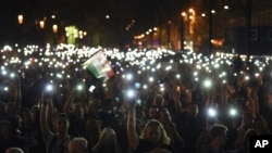 Protesters hold up lit mobile phones during a rally against legislation that could force the closure of the Soros-founded Central European University, in front of Parliament, in Budapest, Hungary, April 2, 2017.