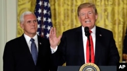 El presidente de EE.UU., Donald Trump habla en una reunión del Consejo nacional del Espacio en la Casa Blanca. Detrás a la izquierda, el vicepresidente Mike Pence. Junio 18, 2018.