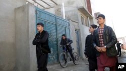 Residents walk pass the house in which Islamic State insurgents were hidden, in a street of Qala-e-Walid neighborhood in Kabul, Afghanistan, Feb. 2, 2018. 