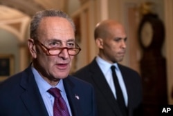 Senate Minority Leader Chuck Schumer, D-N.Y., with Sen. Cory Booker, D-N.J., at right, pauses as they speak to reporters about the political battle for confirmation of President Donald Trump's Supreme Court nominee, Brett Kavanaugh, following a closed-door Democratic policy meeting, at the Capitol in Washington, Oct. 2, 2018.
