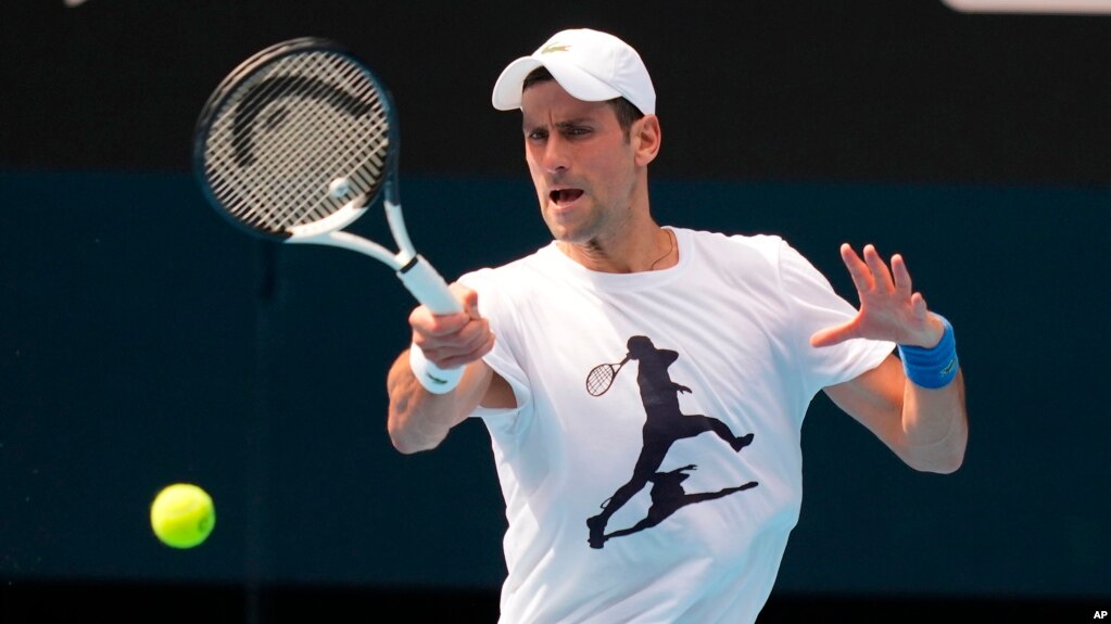 In this photo supplied by Tennis Australia, defending champion Serbia's Novak Djokovic practices in the Rod Laver Arena ahead of the Australian Open at Melbourne Park in Melbourne, Australia, Tuesday, Jan. 11, 2022. 