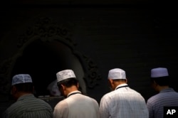 FILE - Chinese Hui Muslims pray during Eid al-Fitr prayers at Niujie Mosque in Beijing, July 18, 2015. Authorities in northwestern China were poised to begin demolition of a mosque Friday, despite protests by hundreds of members of the country's Hui Muslims.