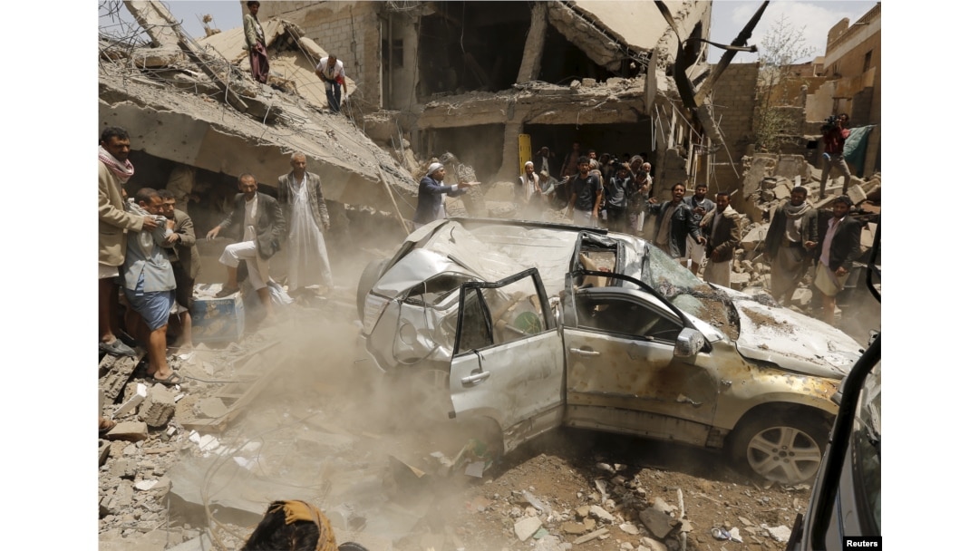 File - A car falls as it is being lifted by a crane at the site of a Saudi-led air strike in Yemen's capital Sana'a Sept. 21, 2015.