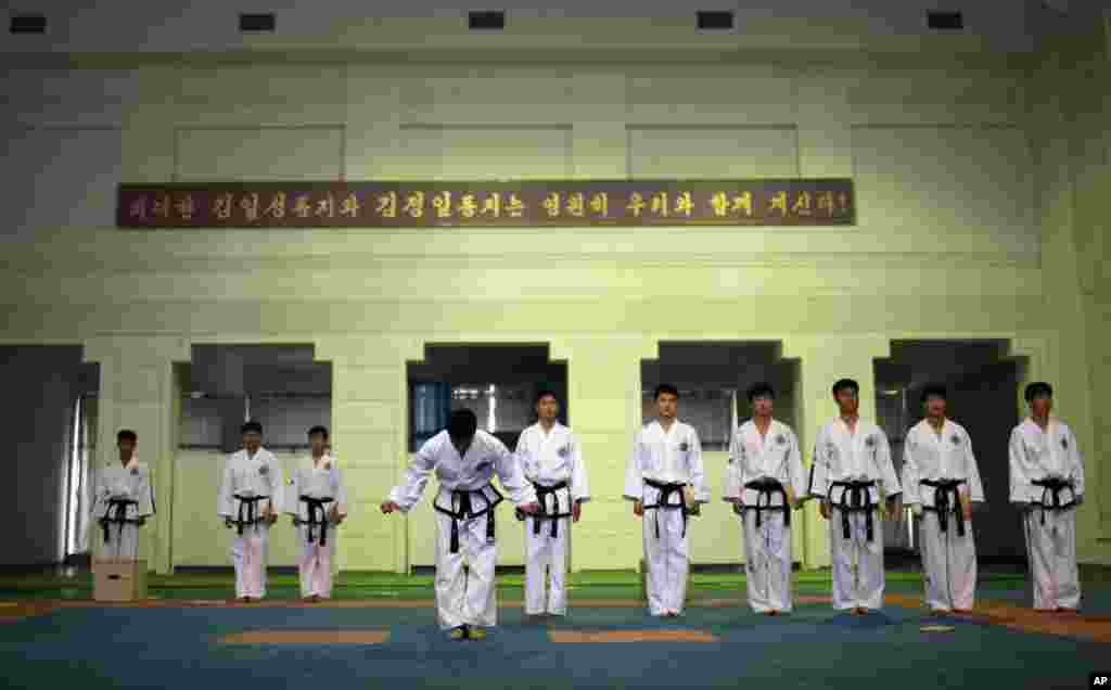 북한 태권도 선수들이 평양 태권도전당에 모인 외신 기자들에게 태권도 시범을 보이기에 앞서 인사하고 있다.