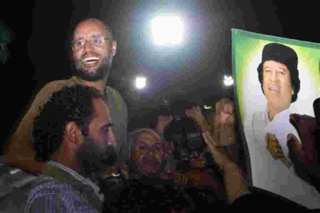 Seif al-Islam saluda a los miembros del equipo pro-Gadhafi en la capital, Trípoli después de desmentir su propia muerte.