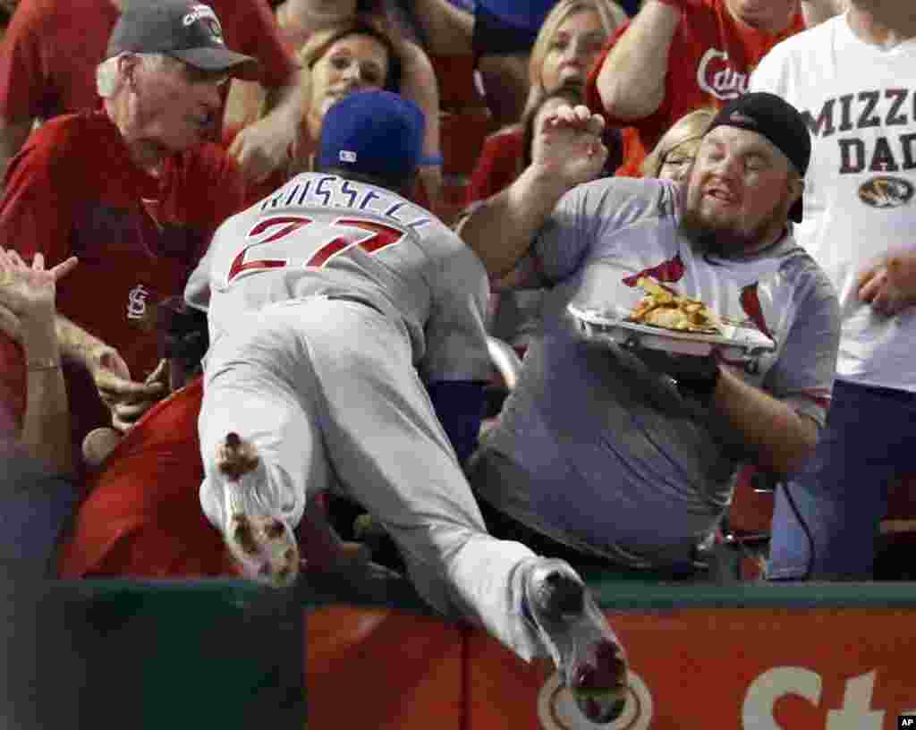 Chicago Cubs shortstop Addison Russell dives into the crowd but is unable to catch a foul ball hit by the St. Louis Cardinals' Jedd Gyorko during the second inning of a baseball game in St. Louis, Missouri, Sept. 25, 2017.