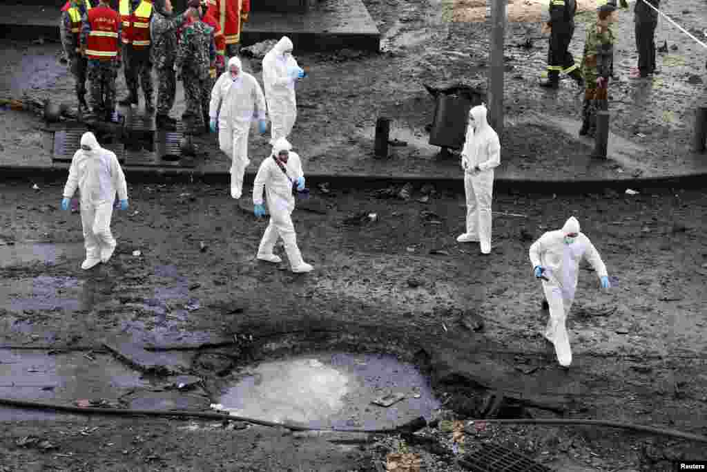Inspectores forenses examinam o local da explosão na Baixa de Beirute, Líbano, Dez. 27, 2013.