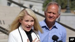 Elizabeth Smart speaks during a news conference while her father, Ed Smart, looks on in Salt Lake City, Sept. 13, 2018. 