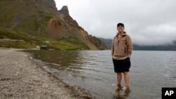 In this Saturday, Aug. 18, 2018, photo, Sinead of Australia stands in the cool water of Lake Chon during a hike arranged by Roger Shepherd of Hike Korea on Mount Paektu in North Korea.