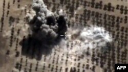 FILE - An image taken from video footage made available on the Russian Defense Ministry's official website purports to show an explosion after airstrikes carried out by Russian air force on what Moscow says was an Islamic State facility in the Syrian province of Idlib, Oct. 15, 2015.