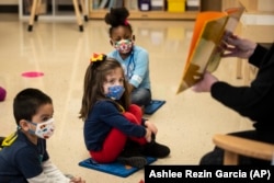 Pre-kindergarten students listen as their teacher reads a story at Dawes Elementary in Chicago, Monday, Jan. 11, 2021.