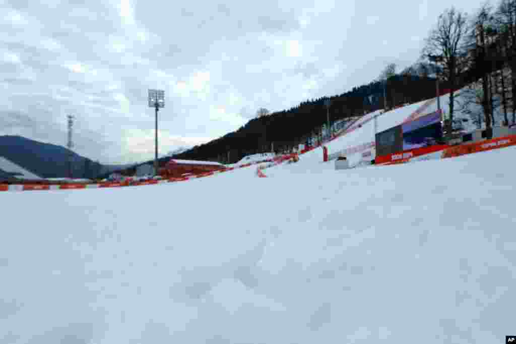 Soft tufts of snow protrude the surface in the finish area of the alpine ski course at the Sochi 2014 Winter Olympics. Warm temperatures in the mountains made the snow too soft and caused the cancellation of women&#39;s downhill training, Krasnaya Polyana, Russia,&nbsp;Feb. 11, 2014.