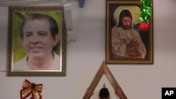 El curandero espiritual tiene imágenes enmarcadas de él y de Jesucristo.