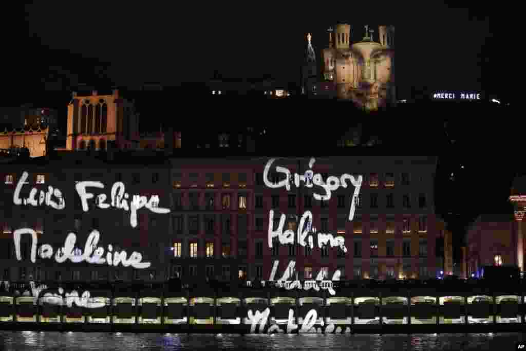 The first names of the 130 Paris attacks victims are projected over buildings in Lyon, central France, during a presentation by French artist Daniel Knipper, Dec. 8, 2015.