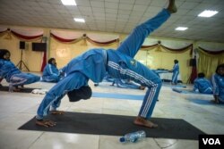 A woman practices a pose during a mind-body wellness program for survivors of trauma in Mogadishu, Somalia, Jan. 16, 2017. (J. Patinkin/VOA)