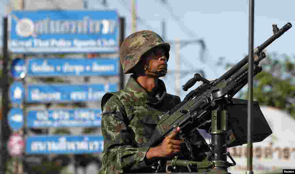 A Thai soldier wields a machine gun as his unit takes its position, in central Bangkok, May 20, 2014.
