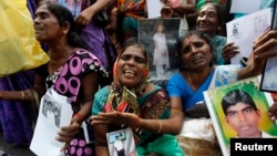FILE - Tamil women cry as they hold up images of their disappeared family members during the war against Liberation Tigers of Tamil Eelam (LTTE) at a protest in Jaffna north of Colombo, Aug. 27, 2013.