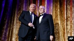 President-elect Donald Trump, left, stands with Vice President-elect Mike Pence during the presidential inaugural Chairman's Global Dinner in Washington, Jan. 17, 2017. 