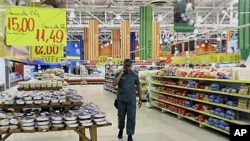 A soldier walks through the Exito hypermarket branch in Valencia, Venezuela, as government officials take over management of the French-owned store, accusing it of price speculation following the country's currency devaluation, Jan 19, 2010 (file photo)