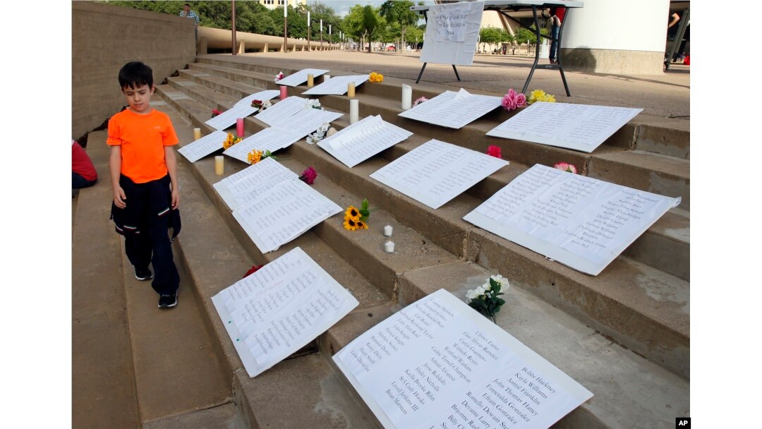 Thomas Baughman, 9, of Dallas, walks past displays with names of people lost to gun violence in Texas, during a protest at City Hall in Dallas, May 4, 2018. The annual National Rifle Association convention is being held nearby at the convention center.