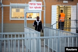 An African migrant walks outside the Holot open detention center, Sept. 22, 2014.