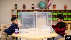 Preschool students eat lunch at Dawes Elementary in Chicago. Pressure is building on school systems around the U.S. to reopen classrooms to students who have been learning online for nearly a year.(Ashlee Rezin Garcia/Chicago Sun-Times via AP, Pool, File)