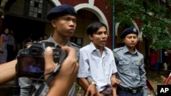 El periodista Kyaw Soe Oo, de 28 años, al centro, abandona la corte después de una audiencia. Su juicio fue postergado hasta el lunes.