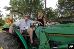 Tom and Heather LaGarde are seen on Tom's tractor at their home near Saxapahaw, N.C., Aug. 29, 2018. The LaGardes left New York following the events of 9/11.